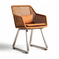 Woven rattan chair with stainless steel frame and accent cushion in orange